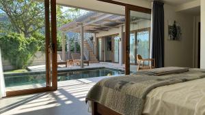 a bedroom with a bed and a swimming pool at Villa Lombok Surga Kedua Setangi in Mangsit