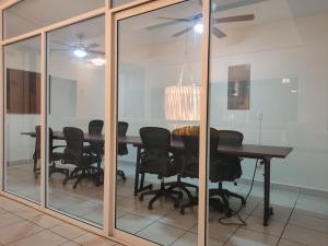 a dining room with glass walls and a table and chairs at Urbania Office Hotel in Tuxtla Gutiérrez