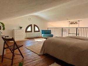 a bedroom with a bed and a chair and a dresser at Dolce Collina, Sunset Terrace & Vineyard Views in Dozza