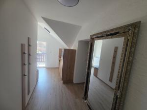 a mirror hanging on a wall in a room at Apartmaji Picasso Design in Veržej +53 photos