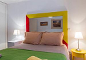 リスボンにあるThe Day Tripper at Chiadoのベッドルーム1室(緑と黄色のヘッドボード付きのベッド1台付)