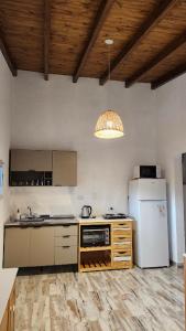 a kitchen with a white refrigerator and a stove at Cabañas Elementos in Huerta Grande +3 photos