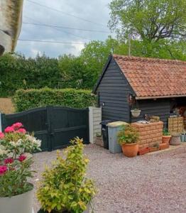 a garden with a black shed and some plants at Maison des Roses in Béalencourt