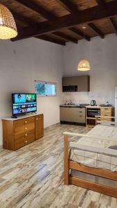 a living room with a bed and a kitchen at Cabañas Elementos in Huerta Grande
