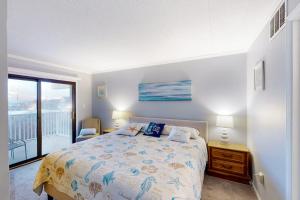 a bedroom with a bed and a balcony at Crystal Sands 403 in Ocean City