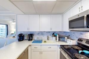 a kitchen with white cabinets and a counter top at Crystal Sands 403 in Ocean City