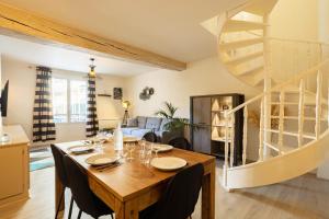 a dining room with a table and a spiral staircase at Duplex hyper centre tout équipé - Arrivée autonome in Troyes