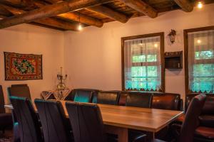 a dining room with a table and leather chairs at Cabana La Urși in Ceraşul +42 photos