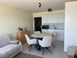 a kitchen and a living room with a table and chairs at Studio Zeester in Westende-Bad