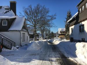a street covered in snow next to a house at Dorfschule Mollseifen in Winterberg