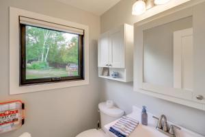 a bathroom with a window and a toilet and a sink at Lakefront Northwoods Cabin w/ Shared Dock & Views! in Tower +18 photos