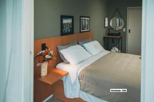 a bedroom with a bed and a vase of flowers at Rio Branco 688 - Hospedagem Premium in Santa Maria