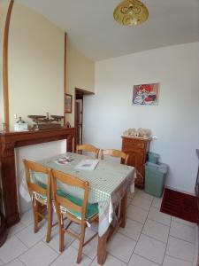 a dining room with a table and chairs and a fireplace at La maison d'Arthur et Armelène in Rely