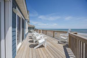 a row of benches sitting on a deck overlooking the ocean at 7048 - Tide Song in Rodanthe