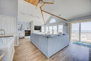 a living room with a couch and a television at 7048 - Tide Song in Rodanthe