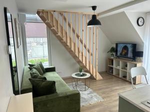 a living room with a green couch and a staircase at Rainbow Palanga in Palanga
