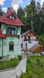 a building with a red roof and a building with a staircase at Casa Criss in Sinaia