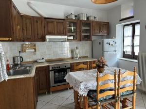 a kitchen with wooden cabinets and a table and a sink at Little Graceland in Afissos