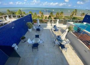 a balcony with chairs and a pool and the ocean at Sol e Mar Solar do Atlântico-Tambaú-João Pessoa in João Pessoa