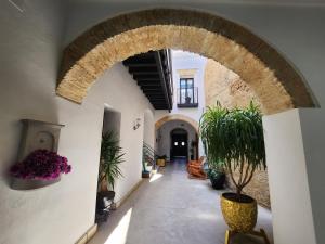 an archway in a building with potted plants at CAMASanlúcar in Sanlúcar de Barrameda