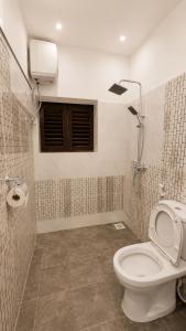 a bathroom with a white toilet and a shower at Serene Abodes in Zanzibar City +11 photos