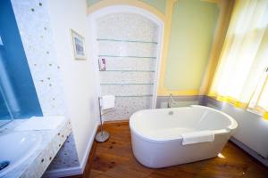 a bathroom with a white tub and a sink at Hotel zum Hofmaler in Potsdam