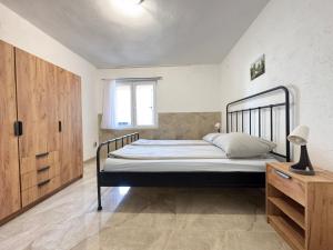 a bedroom with a bed and a wooden cabinet at Lantana ex Villa Americana in Karlobag