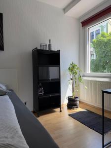 a living room with a television in a black cabinet at Mellow Oak by Interior Apartments - 65qm - 2 Schlafzimmer - Solingen, nahe Köln&Düsseldorf - bahnhofsnah - A1 - Gratis WLAN & TV in Solingen