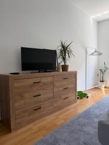 a tv on top of a dresser in a living room at Mellow Oak by Interior Apartments - 65qm - 2 Schlafzimmer - Solingen, nahe Köln&Düsseldorf - bahnhofsnah - A1 - Gratis WLAN & TV in Solingen