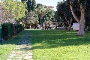 a green park with trees and a walk way at Increíble estudio boutique con vista al mar Mediterráneo in Benalmádena