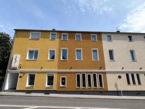 ein gelbes Gebäude am Straßenrand in der Unterkunft WOS Hotel in Mönchengladbach