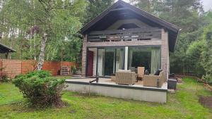 a small house with a deck with chairs in a yard at Kamińsko 544 in Kamińsko +53 photos