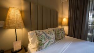 a bedroom with a bed with two pillows and a lamp at Madisson Boutique Hotel Cartagena in Cartagena de Indias