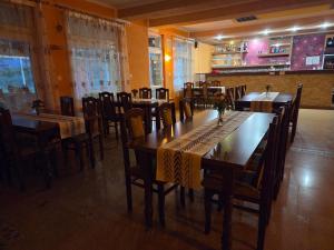 a dining room with wooden tables and chairs at Penzión Poloniny in Ulič