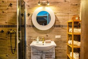 a bathroom with a sink and a mirror at Ostoja Dwa Jeziora in Węgorzewo