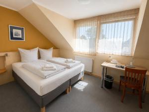 ein Hotelzimmer mit Bett, Schreibtisch und Fenster in der Unterkunft WOS Hotel in Mönchengladbach + 10 Fotos