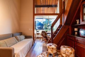 a living room with a couch and a table at Rosa Condomínio Vale azul in Gramado
