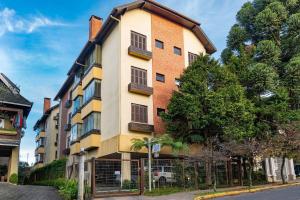 a building on a street with a tree at Rosa Condomínio Vale azul in Gramado