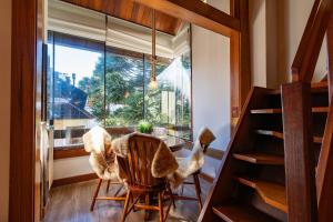 a room with a table and chairs and a window at Rosa Condomínio Vale azul in Gramado