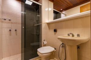 a bathroom with a shower and a toilet and a sink at Rosa Condomínio Vale azul in Gramado +15 photos