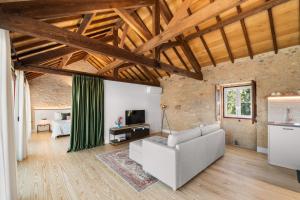 a living room with a couch and a tv at RioVerde Agroturismo in Barcelos