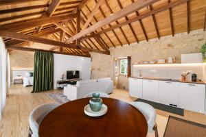 a living room with a wooden table and a kitchen at RioVerde Agroturismo in Barcelos