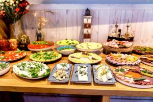 a table with many plates of food on it at Ostoja Dwa Jeziora in Węgorzewo +281 photos