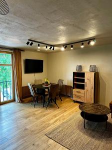 a living room with a table and a television at Four Seasons Apartments in Tukums