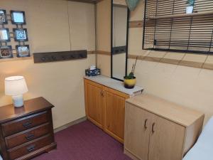 a room with a bed and a dresser and a window at Cozy Tree House in Saint John