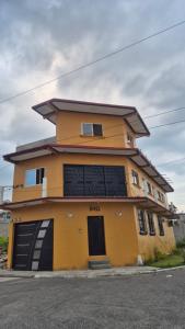 a yellow building with two garage doors on a street at Estadía Climatizada en Escuintla in Escuintla