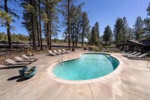 a swimming pool with lounge chairs and a house at Trailhead Lodge in Bend