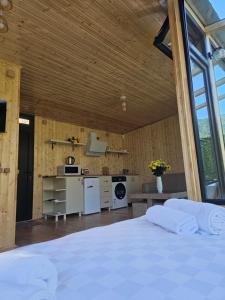 a large bedroom with a white bed and a kitchen at Merisi Horizon in K'eda