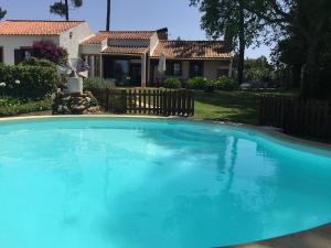 a large blue swimming pool in front of a house at Rustic Villa with Private Pool near Ericeira in Mafra