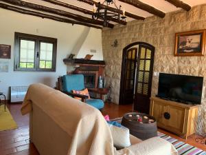 a living room with a couch and a tv at Rustic Villa with Private Pool near Ericeira in Mafra